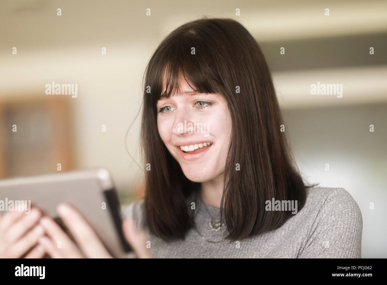 Portrait d'une femme à la recherche d'une tablette numérique à Banque D'Images