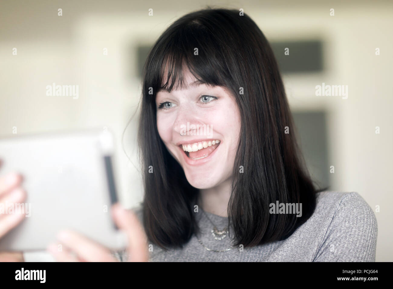 Portrait of a smiling woman looking at a digital tablet Banque D'Images