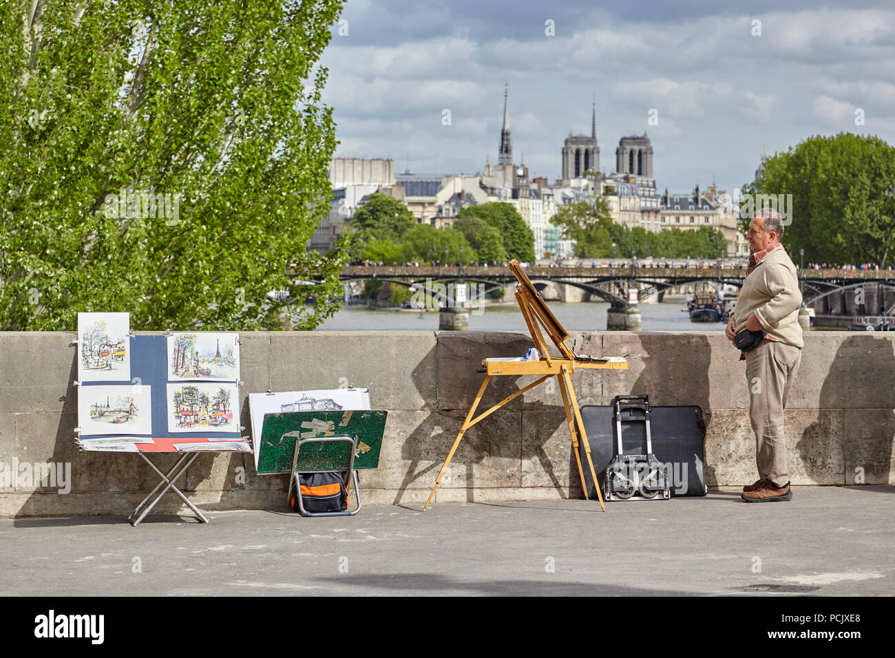 Artiste sur un pont peint et vendant des photos du seine à Paris Banque D'Images