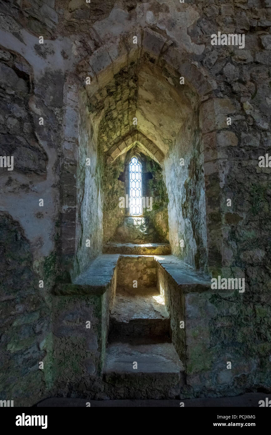 Une fenêtre en pierre à l'intérieur de la tour de siège de la martre, le château de Chepstow, au Pays de Galles Banque D'Images