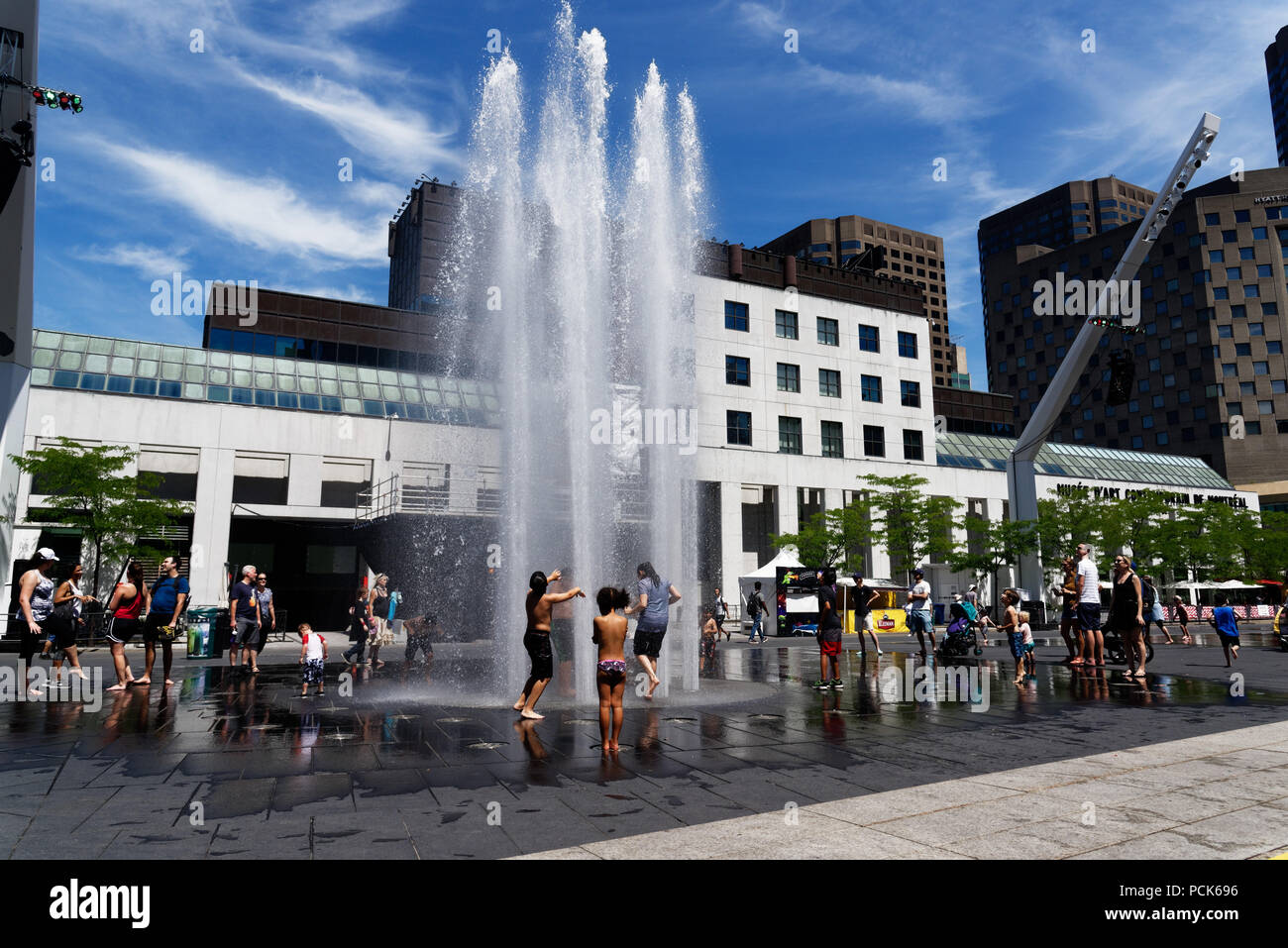 Rafraîchir les enfants jouant dans l'eau des fontaines dans la rue Jeanne Mance Montréal dans le quartier des divertissements. Prises au cours de la canicule de 2108. Banque D'Images
