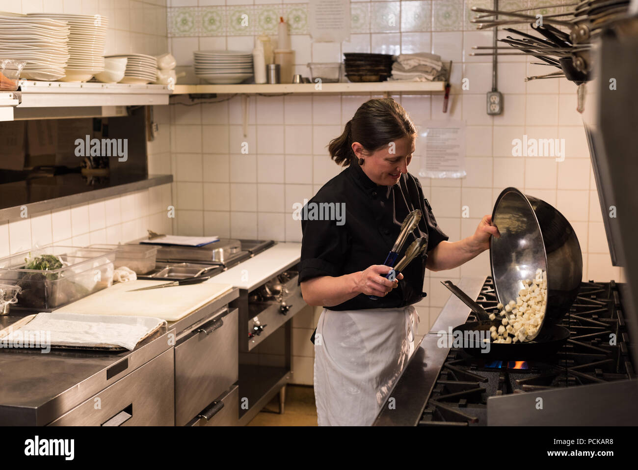 Le chef cooking in commercial Kitchen Banque D'Images