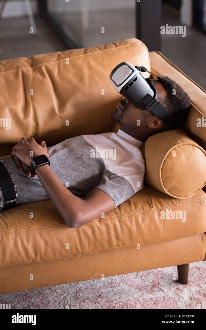 Rencontrez l'homme casque VR couchée sur canapé Banque D'Images