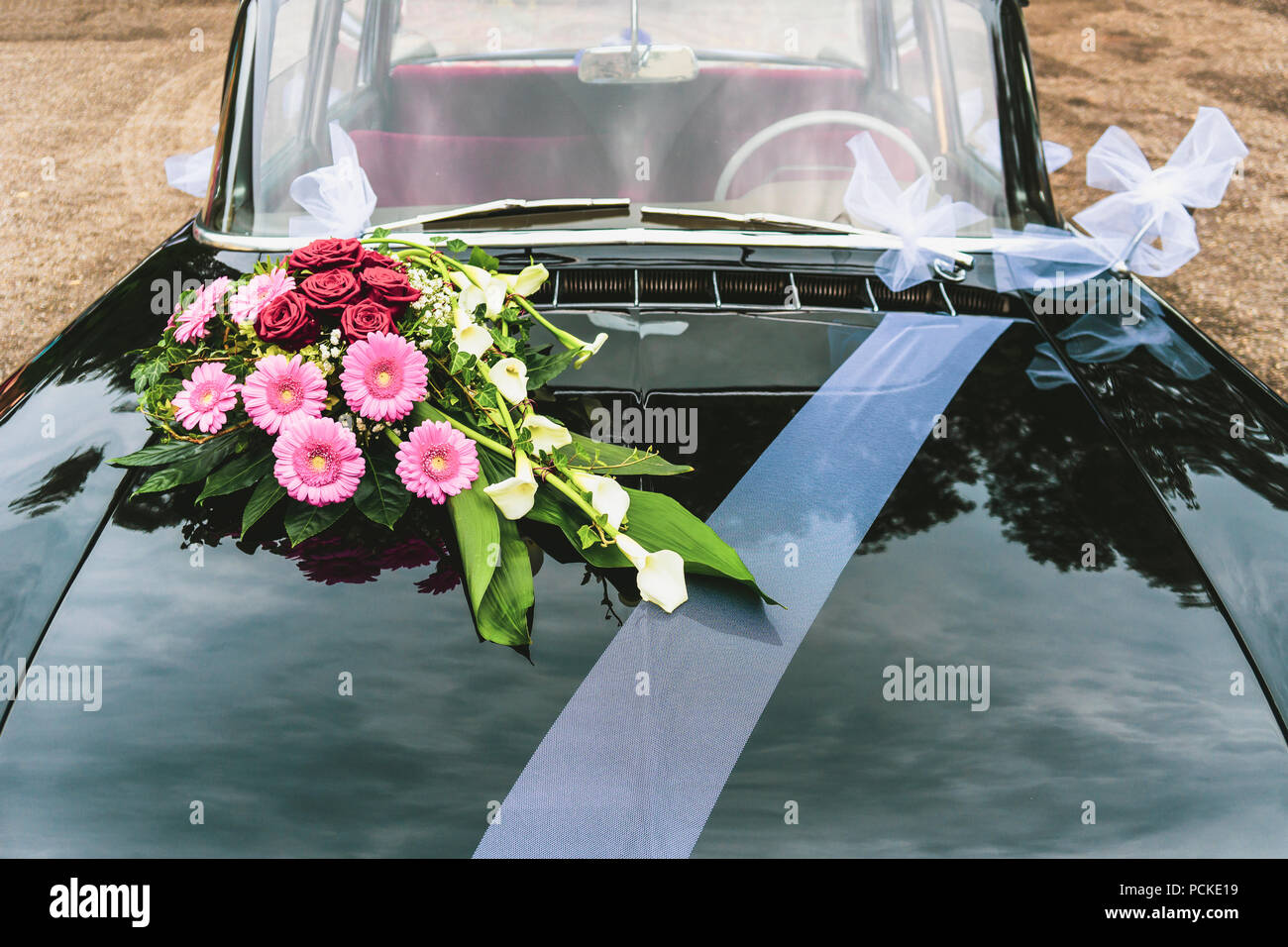Vintage black car décoré de bouqet bouquet de fleurs et ruban blanc pour mariage, France. Banque D'Images