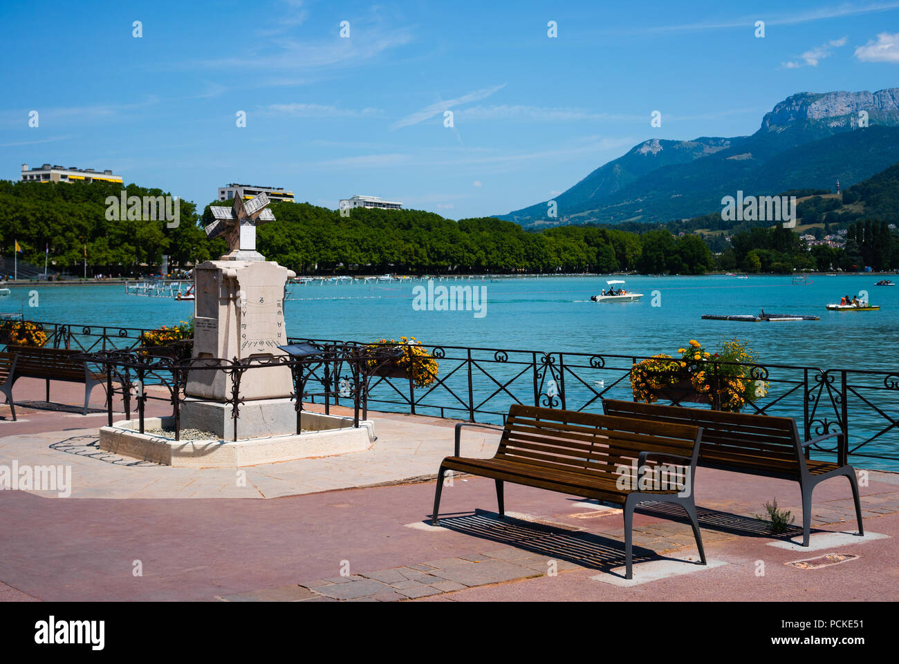 Lac d'Annecy rive avec banc et cadran solaire et Veyrier mont des Alpes montagnes en arrière-plan en France Banque D'Images