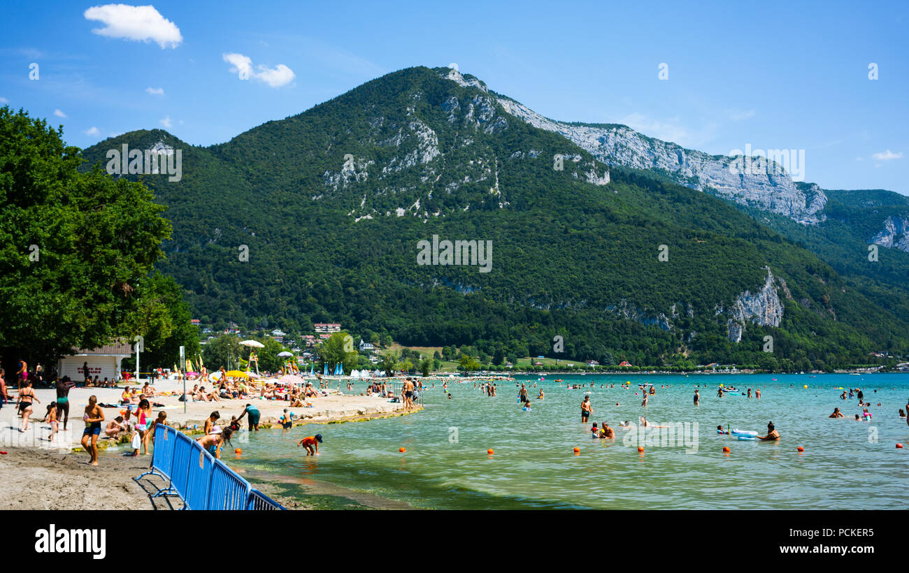 Annecy France, 30 juillet 2018 : Les gens profitant de la journée ensoleillée à Albigny plage et baignade dans le lac d'Annecy Alpes avec montagnes en arrière-plan en Fr Banque D'Images