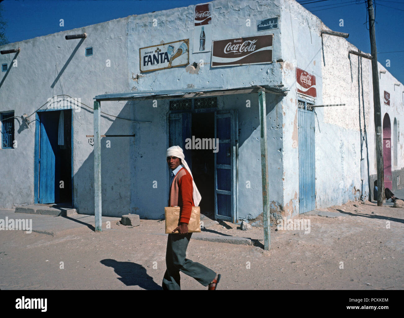 Balades berger arabe en face du bâtiment avec coca cola et boisson à l'orange des signes, Tozeur, Tunisie du Sud, désert du Sahara, l'Afrique du Nord Banque D'Images