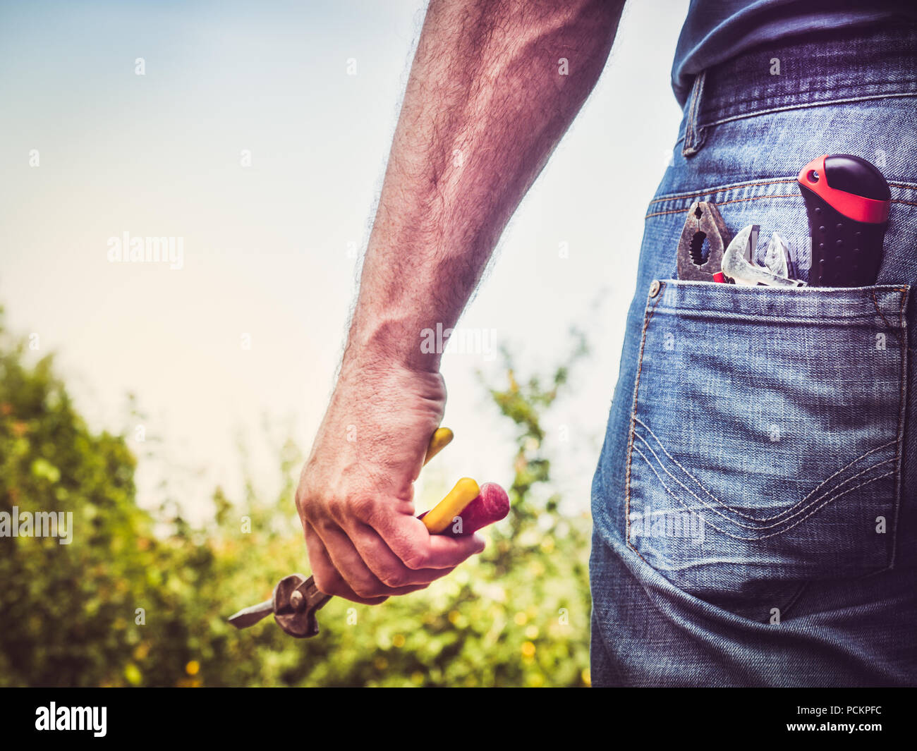 L'homme dans les vêtements de travail avec des outils Banque D'Images