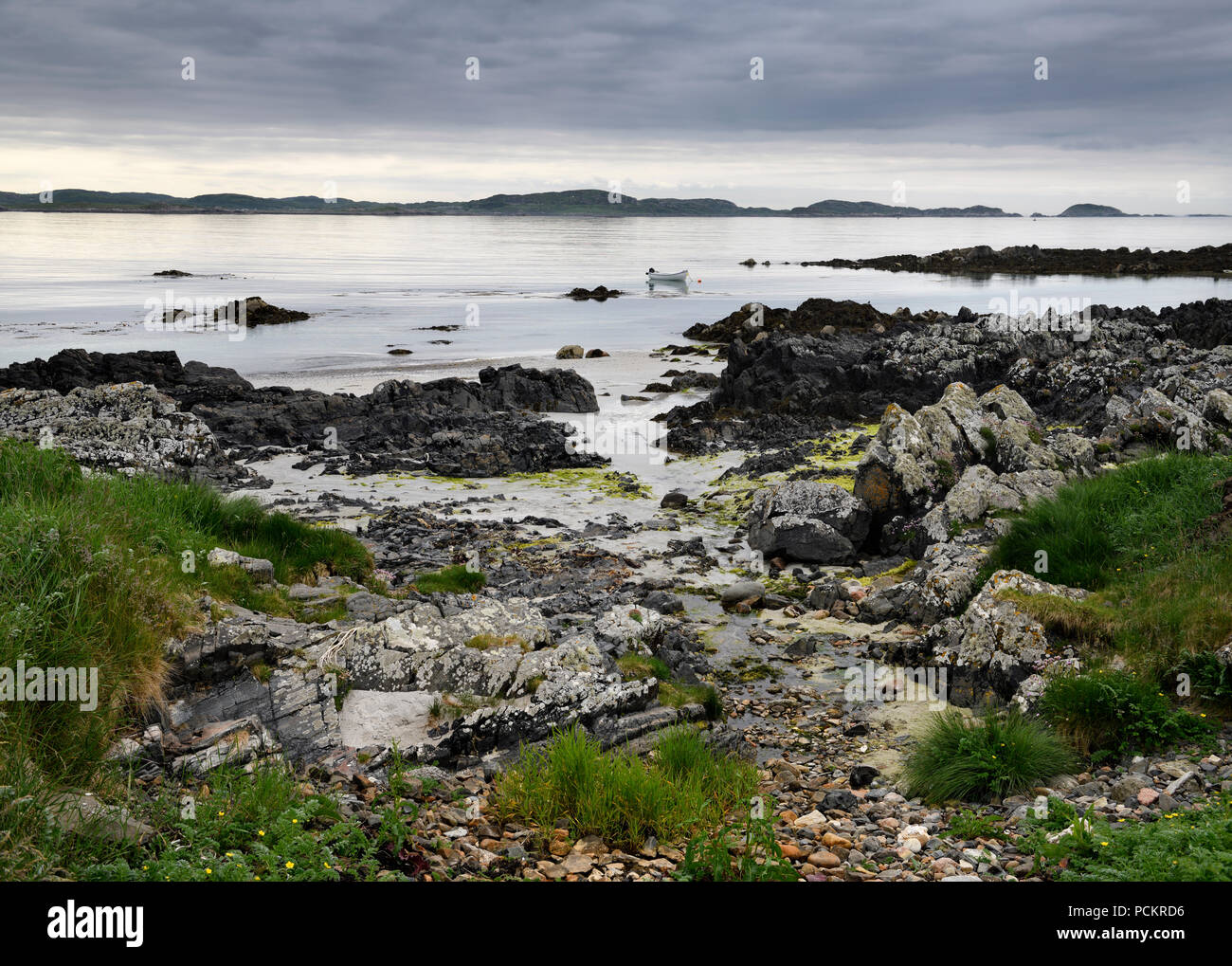 Plage de sable et rochers du littoral et les nuages sur l'île d'Iona avec voile sur son d'Iona Hébrides intérieures Ecosse UK Banque D'Images