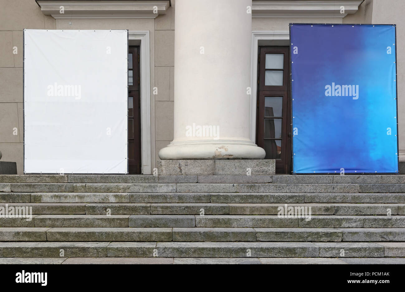 Grand vide en toile de bâche blanc et bleu des bannières de publicité sont installés sur l'échelle de granit de l'ancien bâtiment de la ville. Banque D'Images