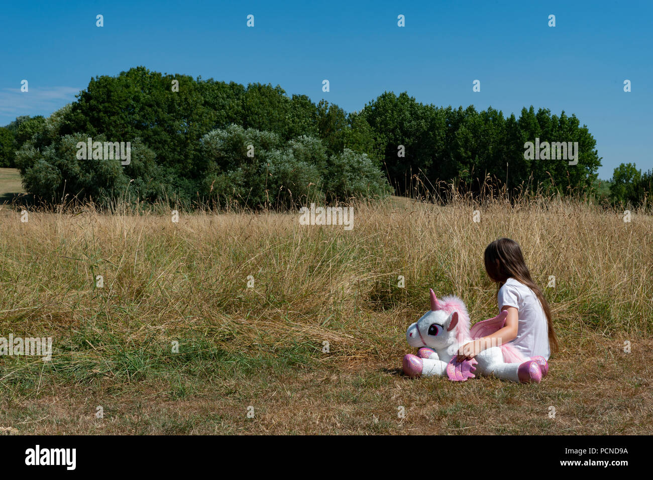 Petite fille dans Parc avec peluche Banque D'Images