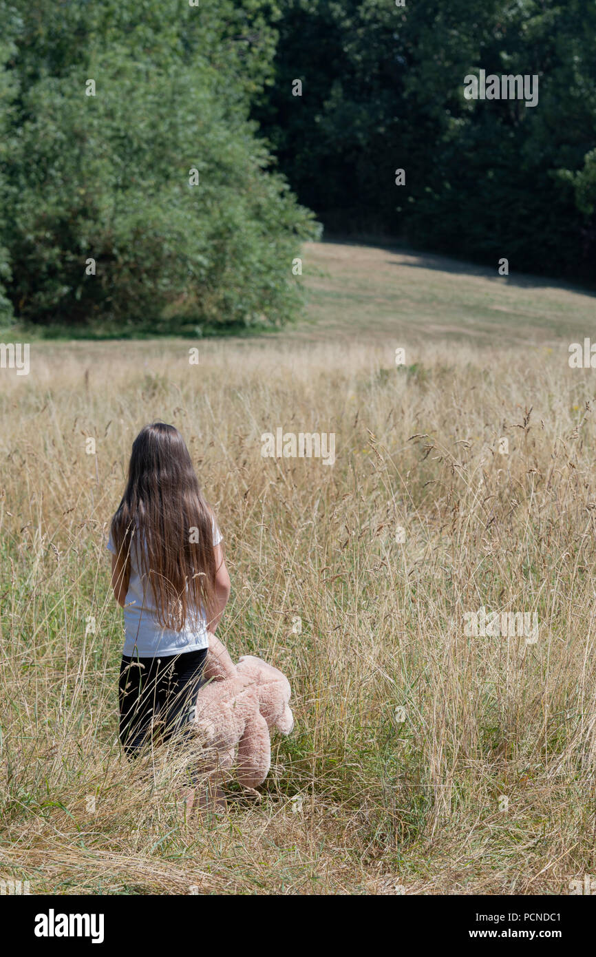 Petite fille dans Parc avec peluche Banque D'Images