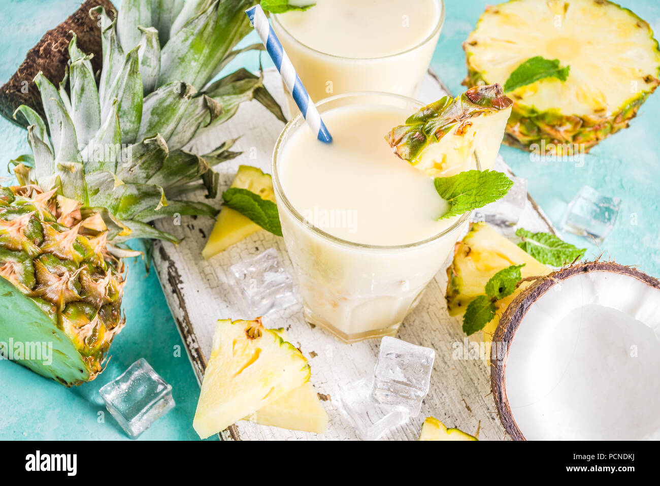 Boisson d'été rafraîchissante, de pina colada cocktail, sur un fond bleu clair, avec des morceaux d'ananas, noix de coco, de glace et de feuilles de menthe, copy space Banque D'Images