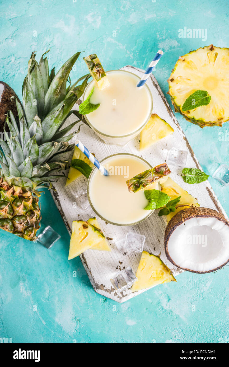 Boisson d'été rafraîchissante, de pina colada cocktail, sur un fond bleu clair, avec des morceaux d'ananas, noix de coco, de glace et de feuilles de menthe, copy space Banque D'Images