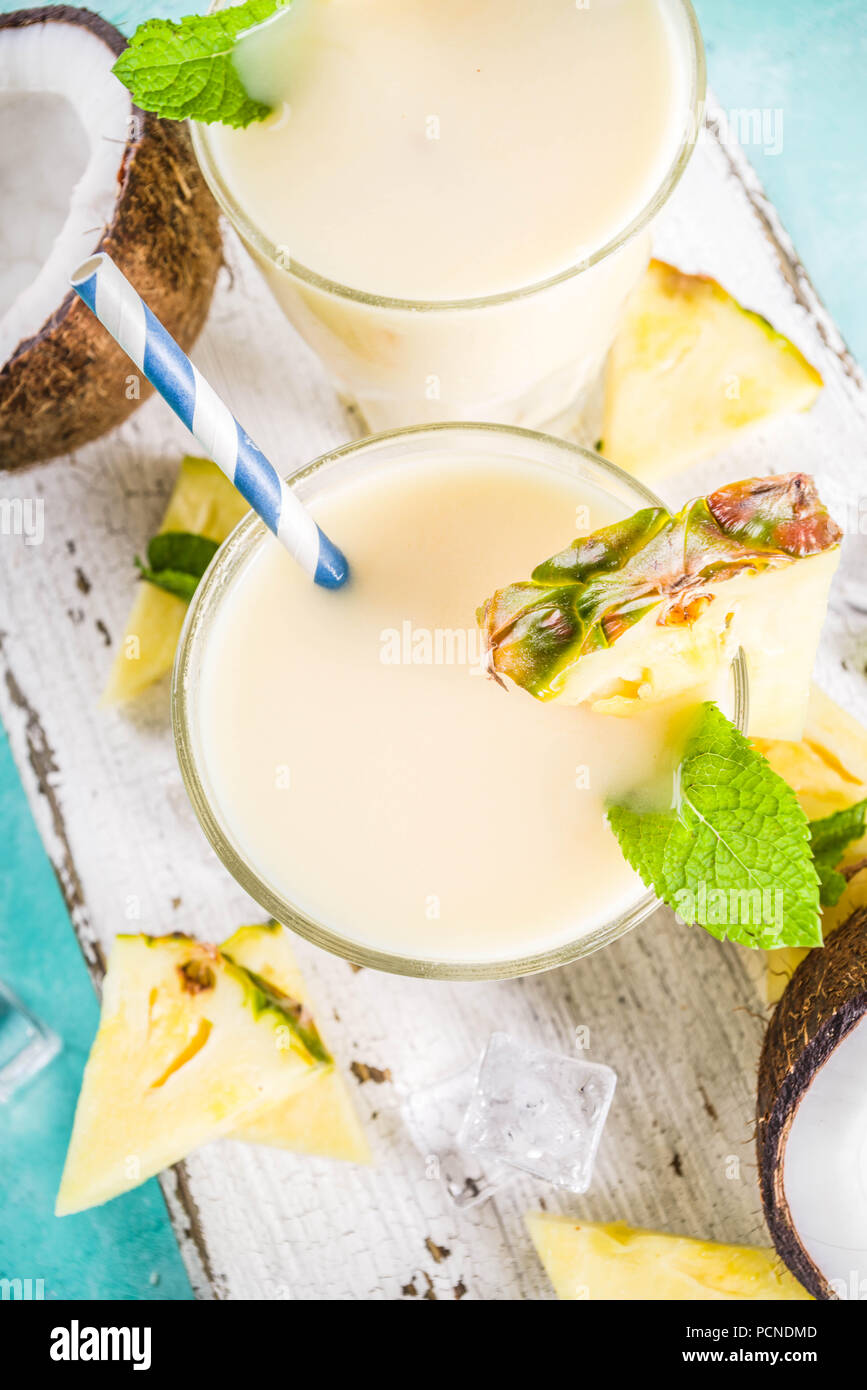 Boisson d'été rafraîchissante, de pina colada cocktail, sur un fond bleu clair, avec des morceaux d'ananas, noix de coco, de glace et de feuilles de menthe, copy space Banque D'Images