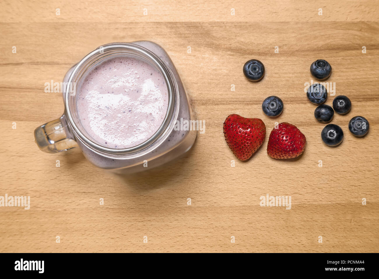 Smoothie aux petits fruits dans un pot Mason avec fraise et myrtille sur Banque D'Images