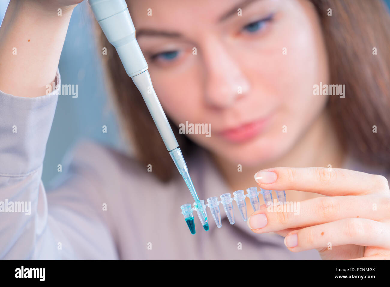 Technicien de sexe féminin à la pipette dans cont pour des tests médico-légaux ADN Banque D'Images