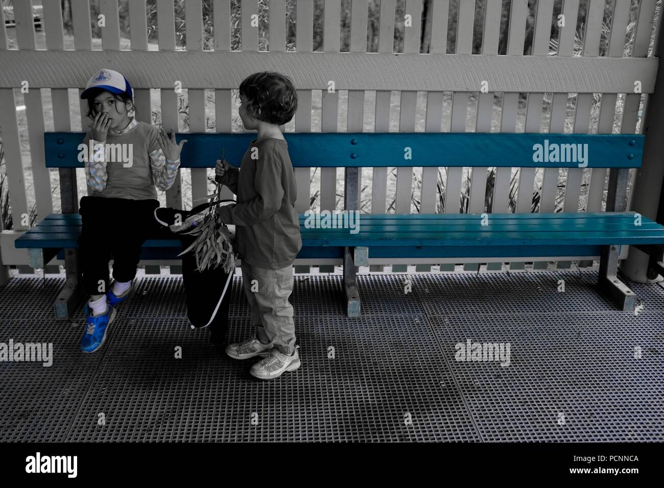 Deux jeunes filles assises sur un banc, filtre bleu, Cardwell, Queensland, Australie Banque D'Images