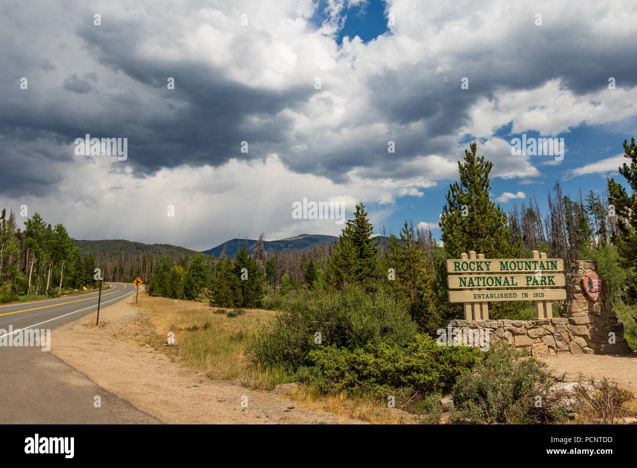 ROCKY MOUNTAIN NATIONAL PARK, CO-17 le 18 juillet : panneau d'entrée de parc, avec route menant au loin sur la gauche. Banque D'Images