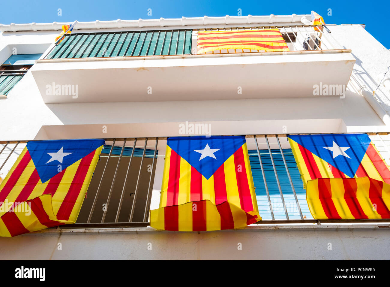 Trois drapeaux indépendantistes connu comme Esteladas suspendu au balcon d'une maison dans une ville sur la Costa Brava, dans la province de Gérone en Catalogne Espagne Banque D'Images