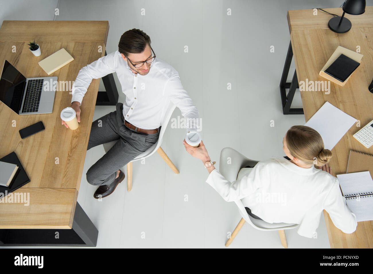 Vue aérienne de jeunes collègues d'affaires avec les gobelets de café assis au bureau Banque D'Images