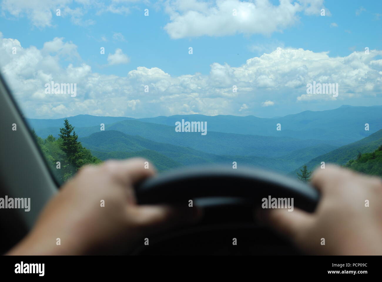 L'homme regardant le paysage de montagne à travers la fenêtre de voiture. Homme de main sur le volant. Concept de la fin de la route Banque D'Images