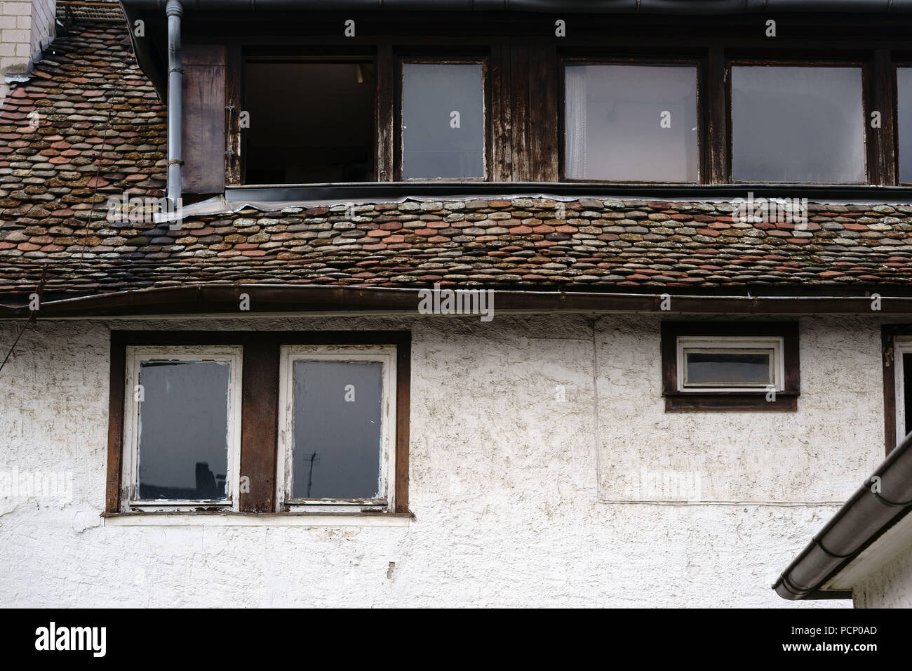 Se penchant, délabré et nostalgique et windows d'un vieux bardeaux de toiture et bâtiment classé. Banque D'Images