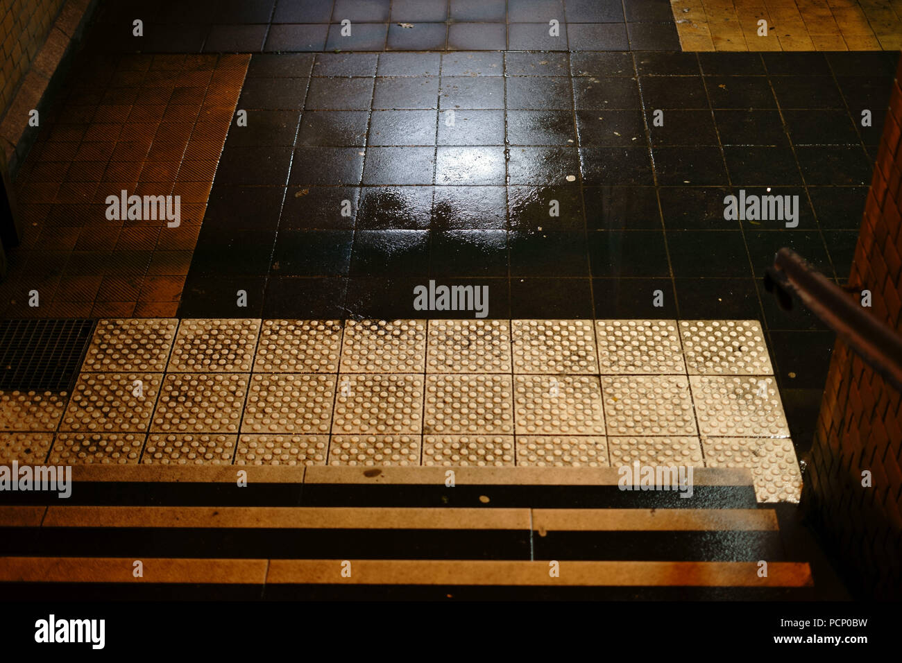 Les étapes d'un sombre tunnel de la station avec les flaques et les murs humides. Banque D'Images