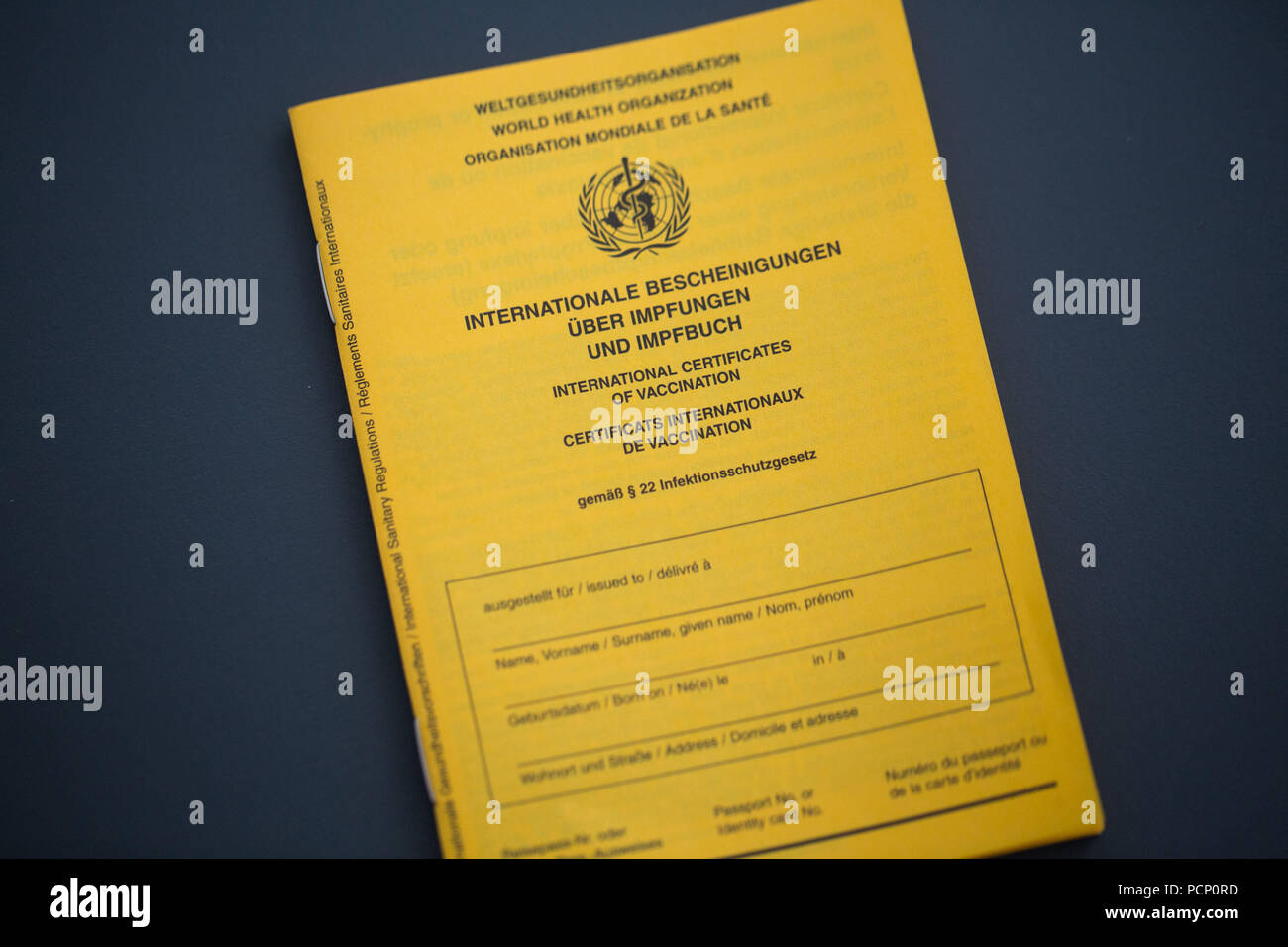 Certificat de vaccination, international, jaune, coupé sur fond sombre Banque D'Images