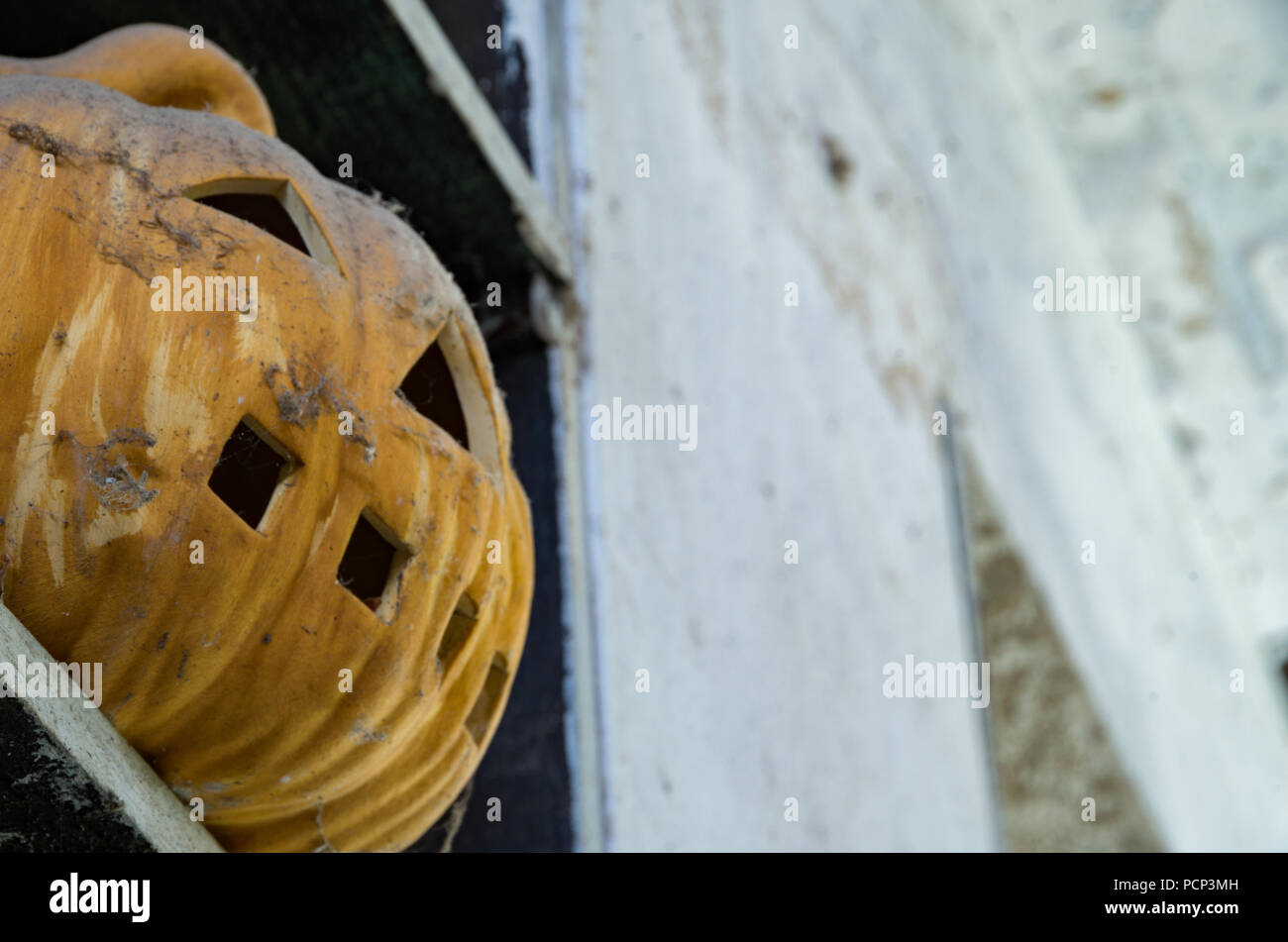 Vieux Jack O Lantern assis sur un plateau couvert de poussière Banque D'Images