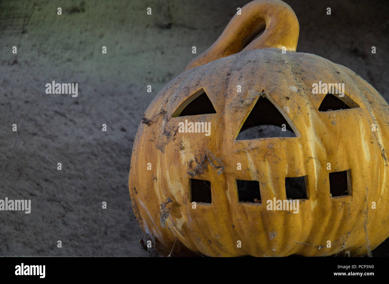 Vieux Jack O Lantern assis sur un plateau couvert de poussière Banque D'Images