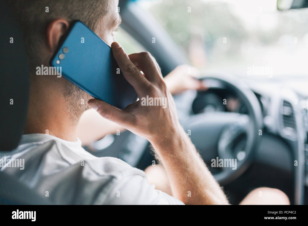 Careless pilote à l'aide de son téléphone portable tout en conduisant une voiture Banque D'Images