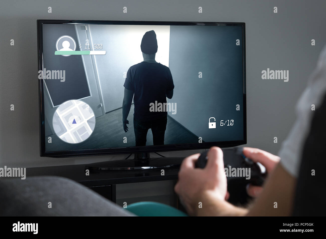 Jouer à des jeux vidéo à la maison avec la console. Avec contrôleur de joueur ou une manette en main. Jeune homme et d'une télévision avec jeux d'action à l'écran. Banque D'Images