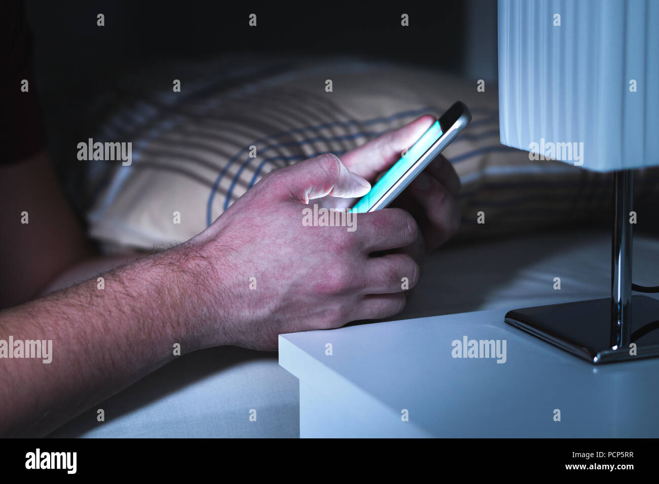 Man using smartphone au lit tard, au milieu de la nuit. Téléphone mobile dans la chambre. Un message SMS ou en utilisant les médias sociaux. Téléphone cellulaire de la toxicomanie. Banque D'Images