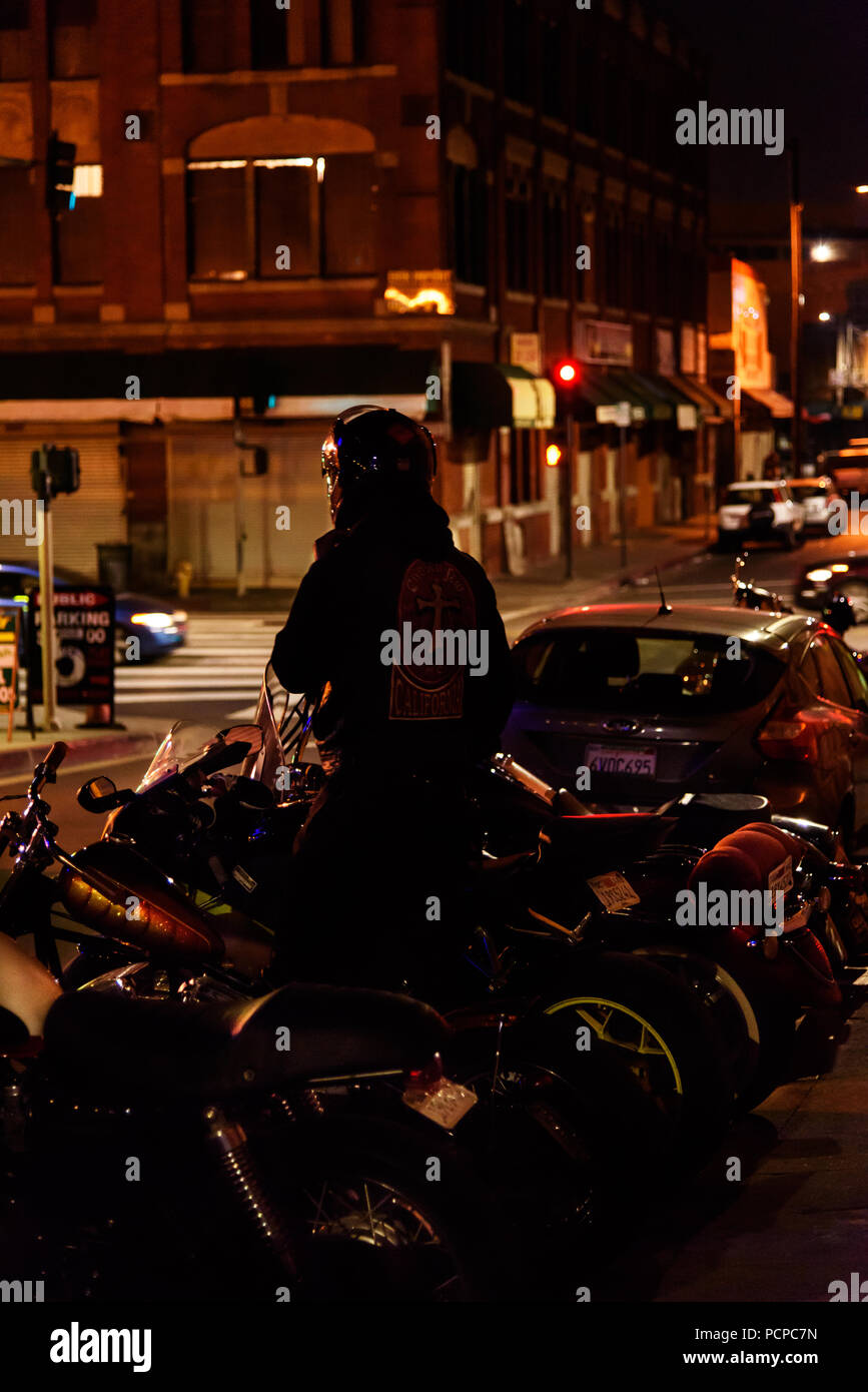 Club de moto, un MC de fixation de sa moto motard dans les rues du centre-ville de Los Angeles la nuit. Banque D'Images