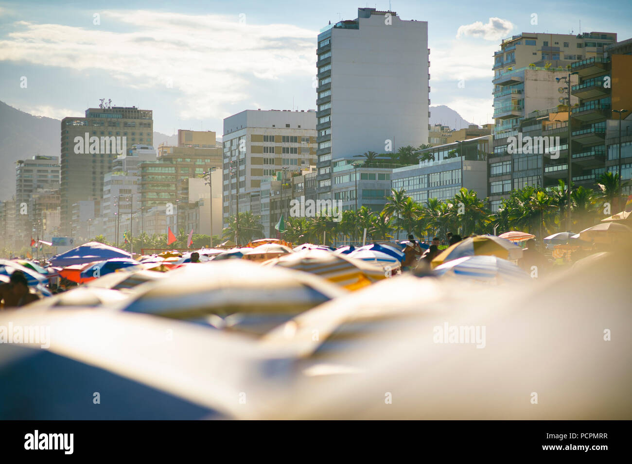 Brumeux de l'été vue sur la cime des parasols sur une plage bien remplie à plus de la promenade. doublure hôtels Banque D'Images