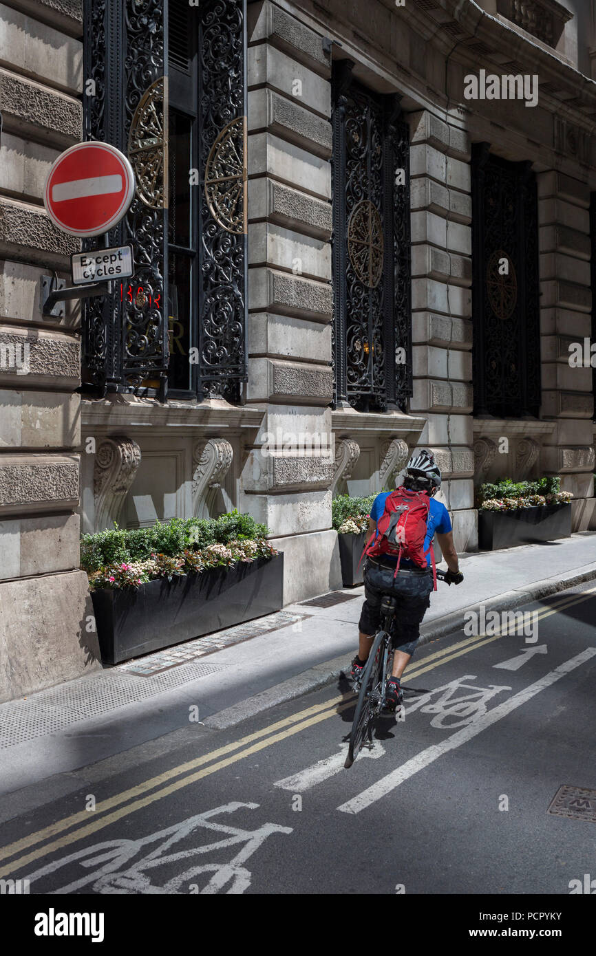 Un cycliste se tourne sur une voie cyclable sur la rue Finch, un étroit couloir de l'époque médiévale dans la ville de Londres, la capitale historique du quartier financier, le 2 août 2018, à Londres, en Angleterre. Banque D'Images