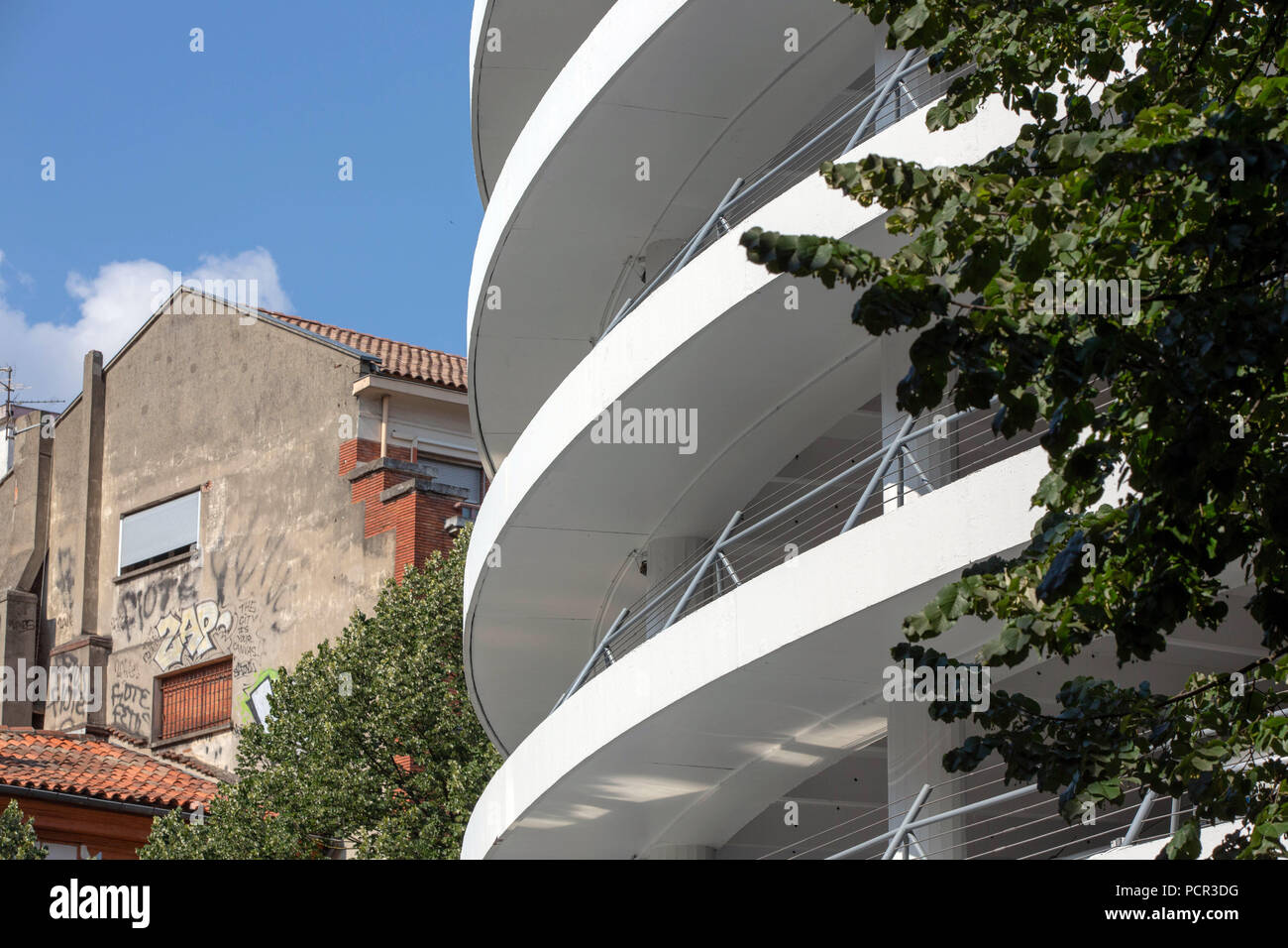 FRANCE, TOULOUSE - Juillet 9, 2018 : la spirale restauré Les Carmes parking  à côté d'un vieux bâtiment en brique avec des graffitis Photo Stock - Alamy