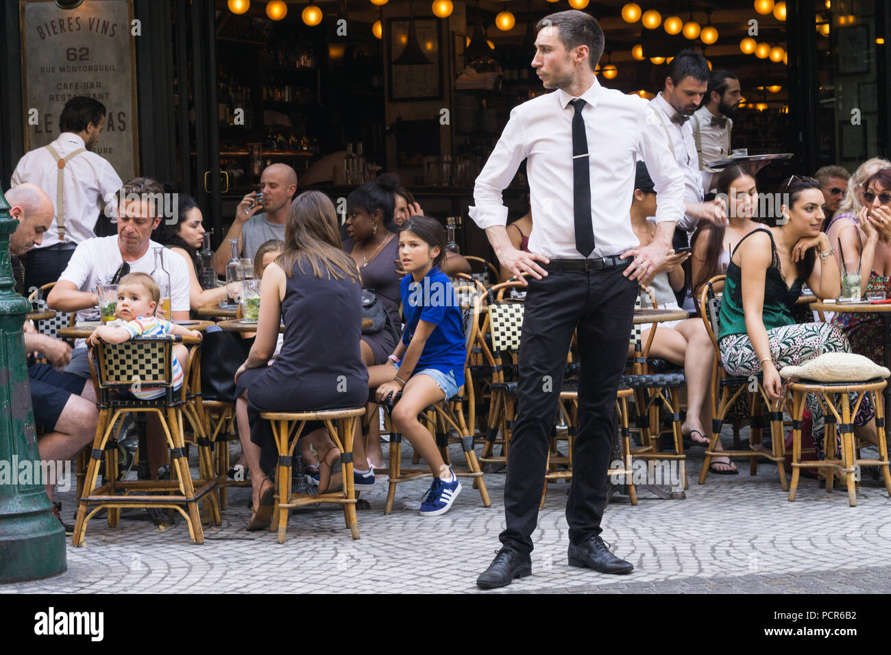 Paris France - hôtellerie hôtellerie debout devant le restaurant sur la rue Montorgueil, Paris, France, Europe. Banque D'Images