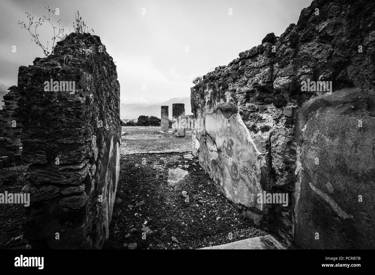 Mur et deux colonnes sur une place dans les ruines de la ville antique de Pompéi, près de Naples, Italie Banque D'Images