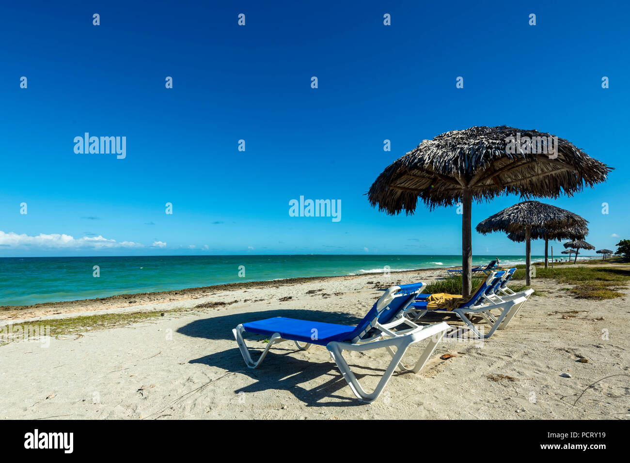 Des chaises longues à la plage, parasols faits de feuilles de palmiers, la plage de l'hôtel le matin Resort & Spa Paradisus Varadero Varadero, eaux turquoise, sable fin, Cuba, Matanzas, Cuba, Amérique du Nord Banque D'Images