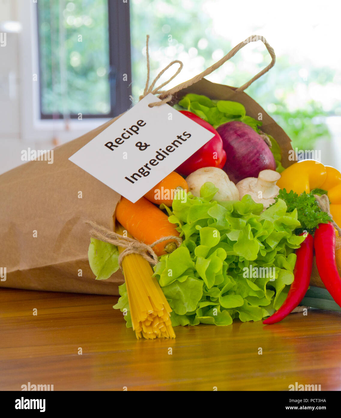 Les légumes biologiques frais de livraison des aliments en sac de papier sur banc en bois dans la cuisine Banque D'Images