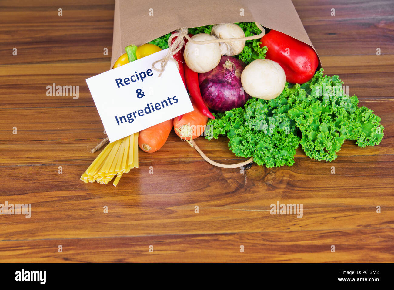 Les légumes biologiques frais de livraison des aliments en sac de papier sur banc en bois dans la cuisine Banque D'Images