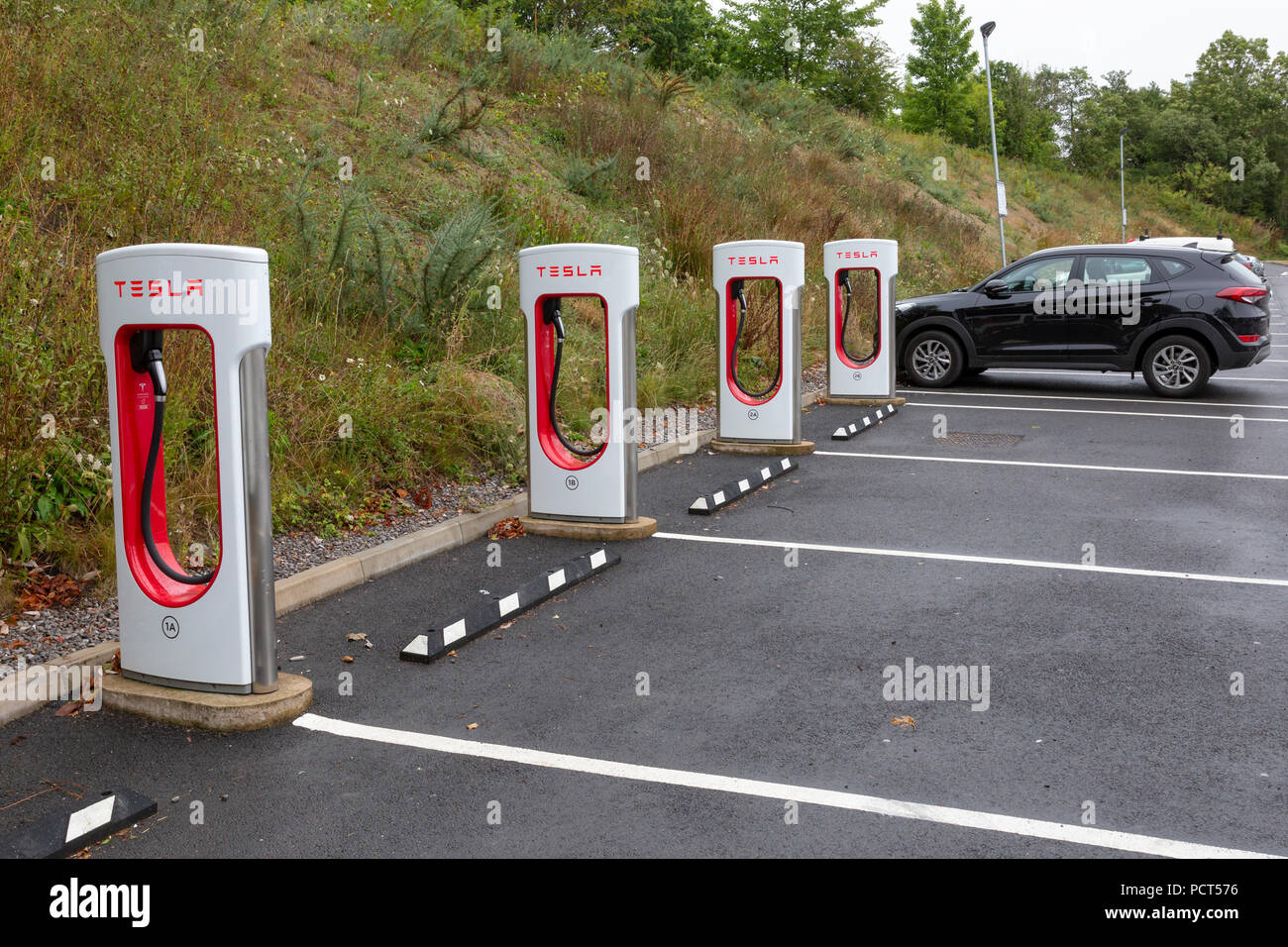 SARN, Royaume-Uni - 2 août 2018 : Une rangée de Tesla Compresseurs à côté des aires de stationnement vide au parc Sarn services d'autoroute à la sortie de l'autoroute M4 près de bri Banque D'Images