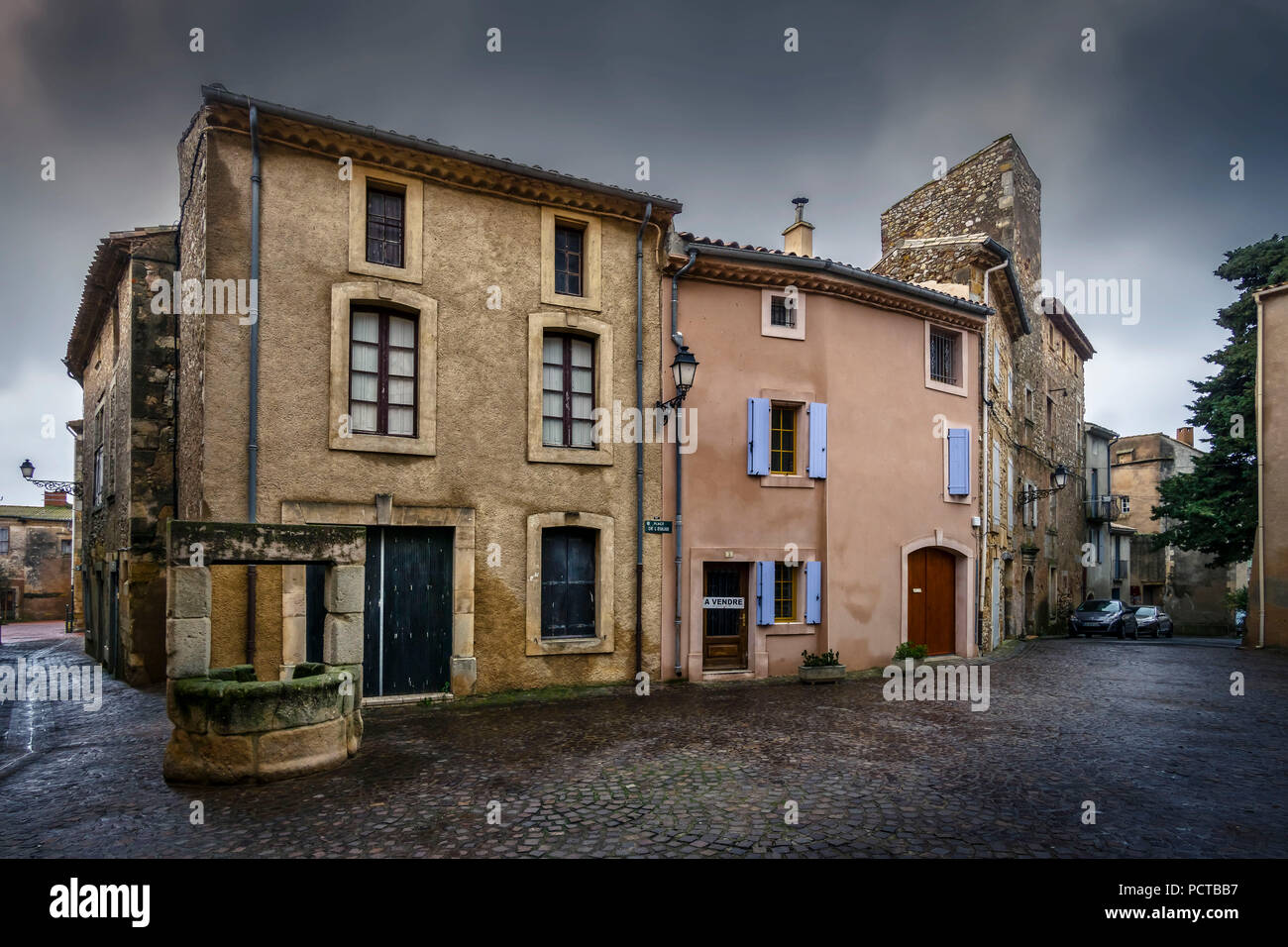 Cruzy, Place de l'Eglise à Cruzy avec fontaine en pierre ancienne Banque D'Images