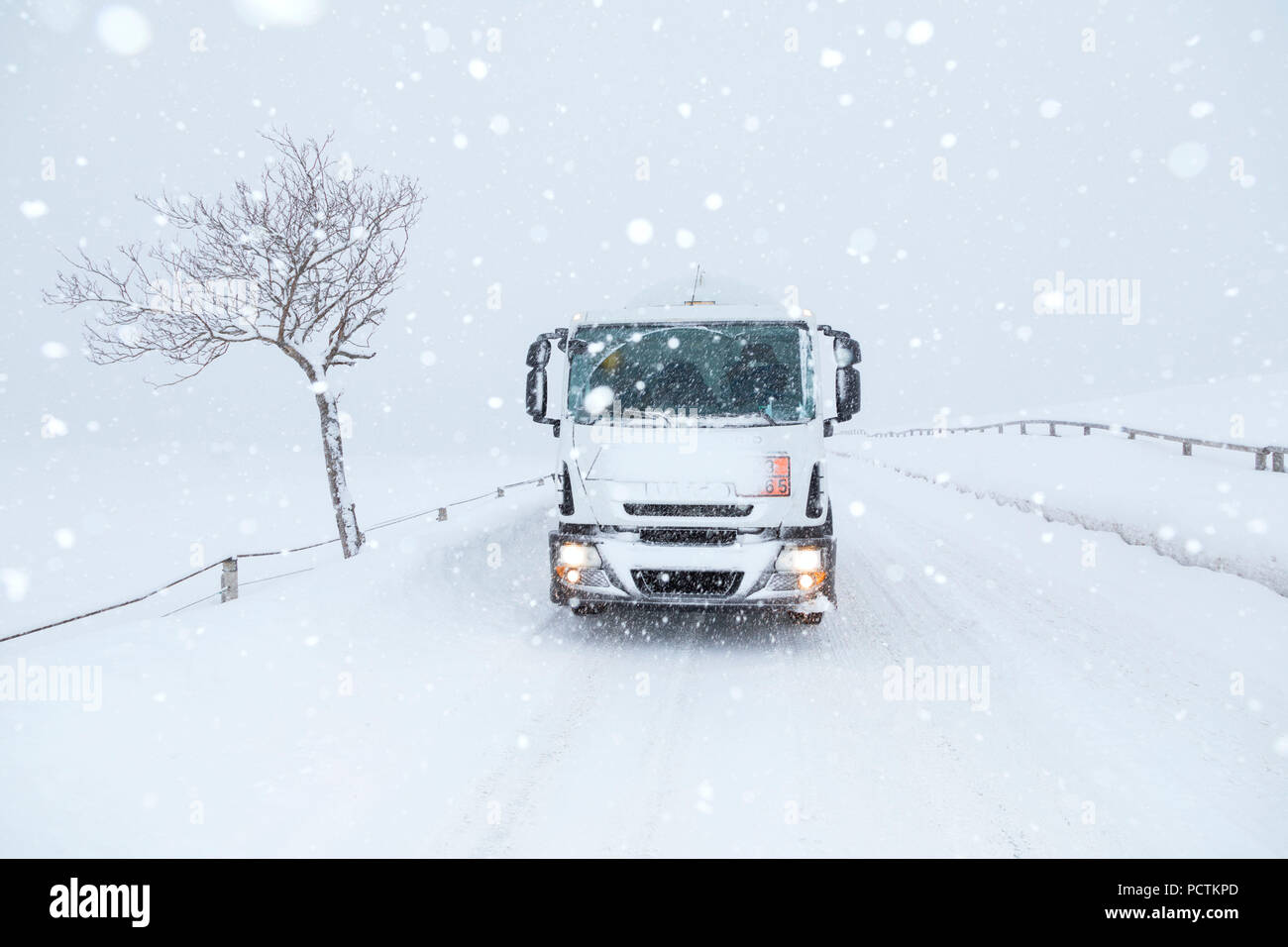Livraison de gaz GPL en hiver sur route de montagne sous des chutes de neige importantes, Dolomites, Veneto, Italie Banque D'Images