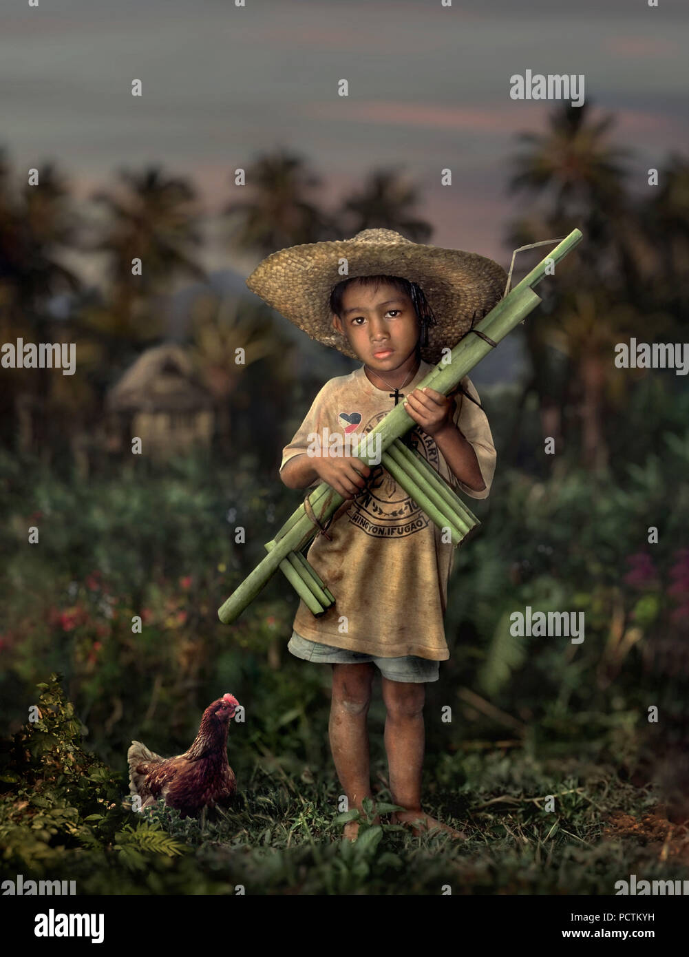 Garçon avec des armes à feu de bambou et le poulet, Hingyon, Ifugao, l'île de Luzon, Philippines Banque D'Images