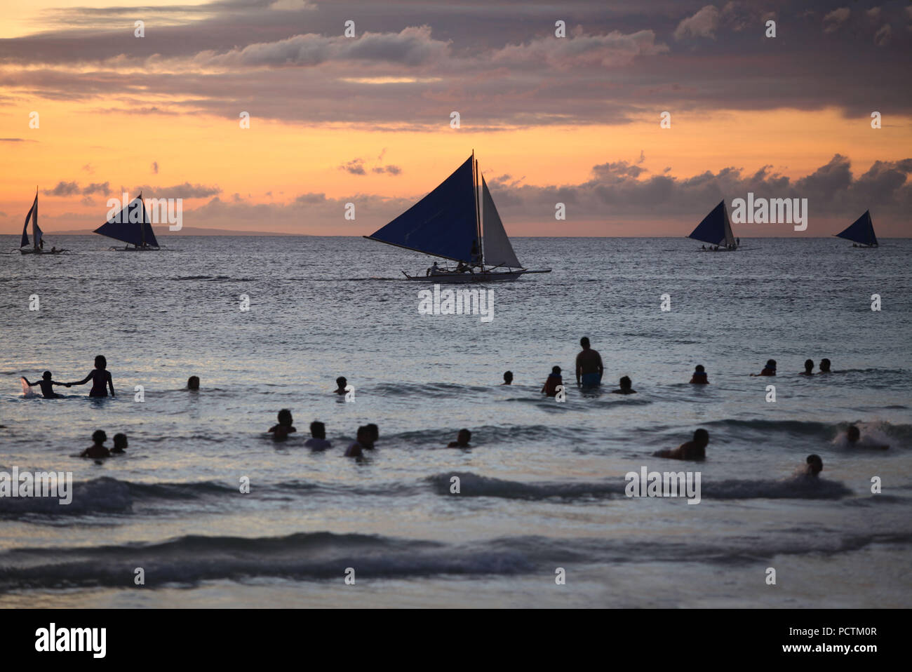 Les nageurs et les voiliers au coucher du soleil, Boracay, Philippines, Asie Banque D'Images