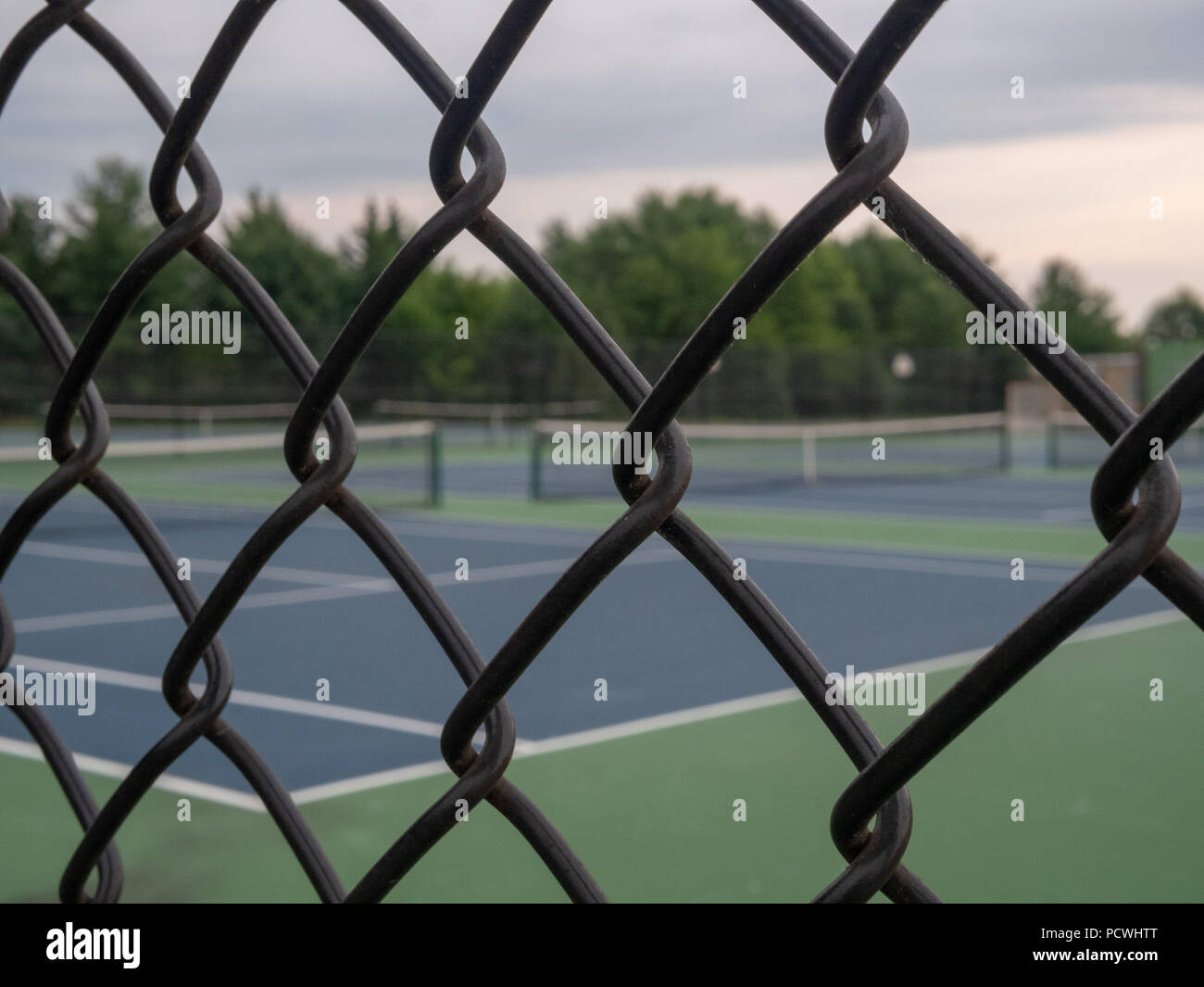 Tennis en arrière-plan noir avec encadrement clôture en premier plan Banque D'Images