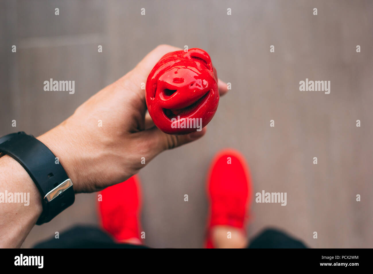 Vue du dessus de l'homme tenant une rafraîchissante de cône de glace à la framboise et vous pouvez voir ses chaussures rouges Banque D'Images